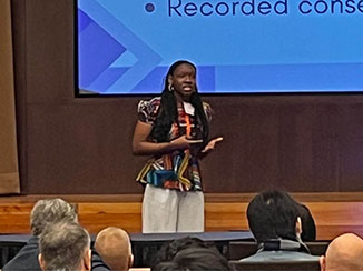 Female presenter standing in front of a group of people