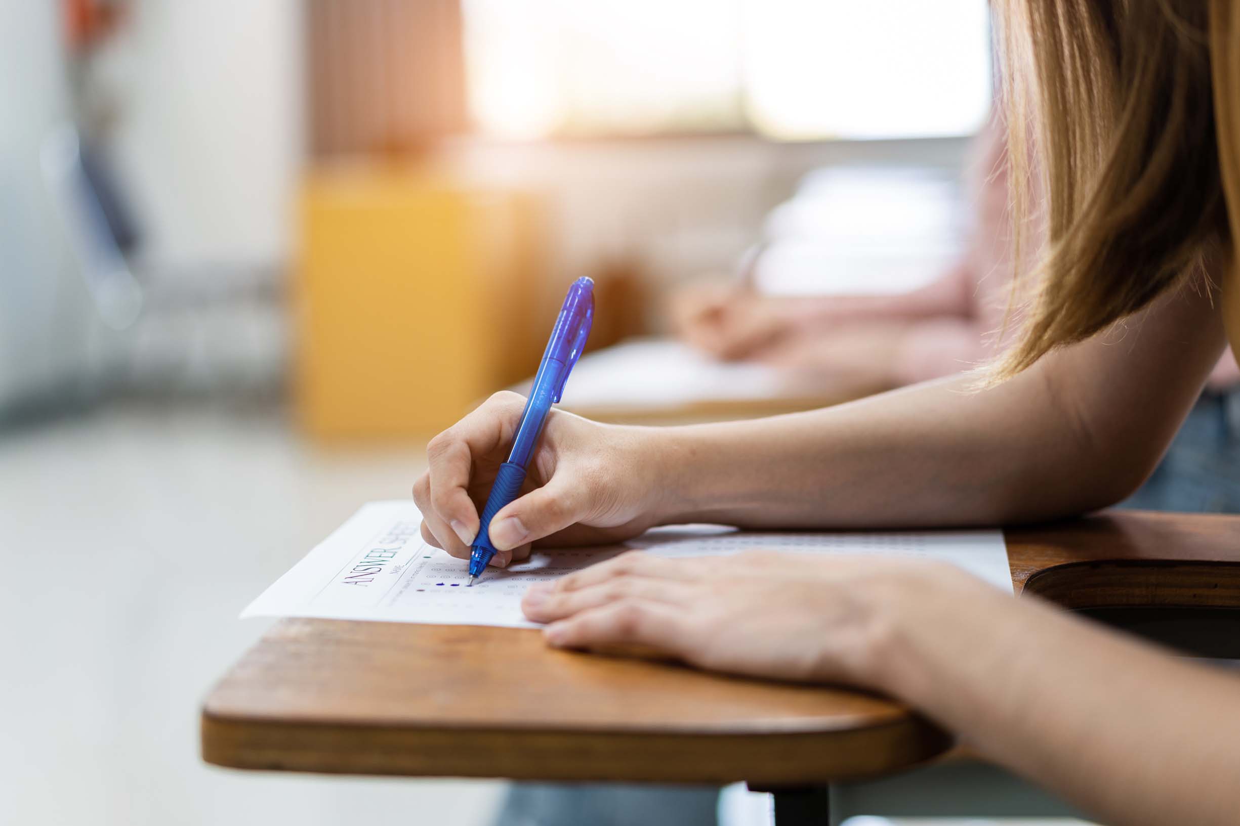Student writes the answer of the examinations on answer sheet in the classroom.