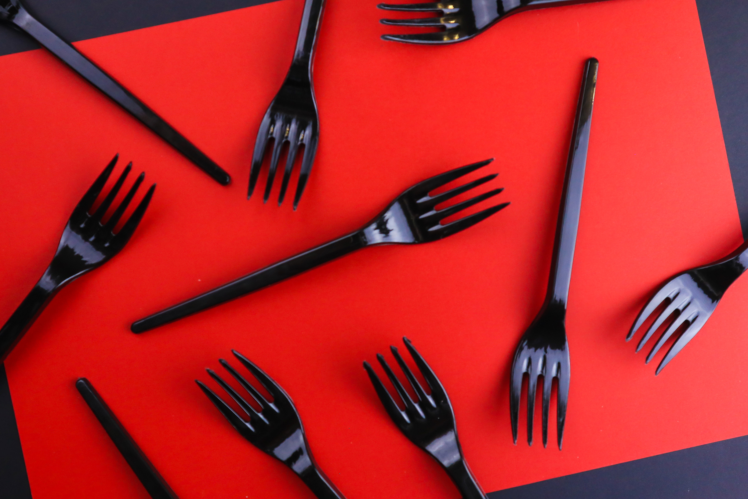 Black forks strewn across a red background.