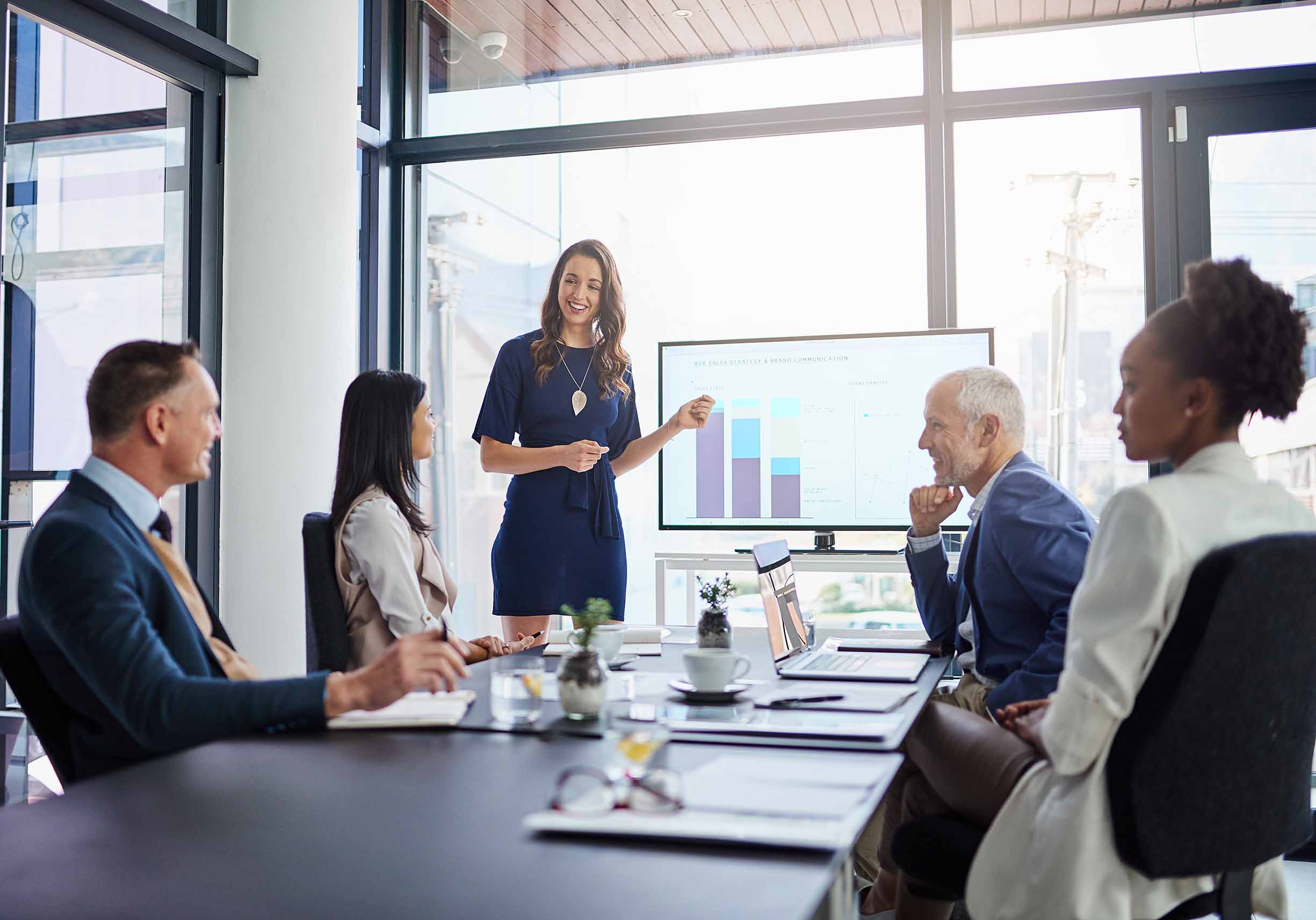 Businesswoman giving a statistic presentation in a boardroom.
