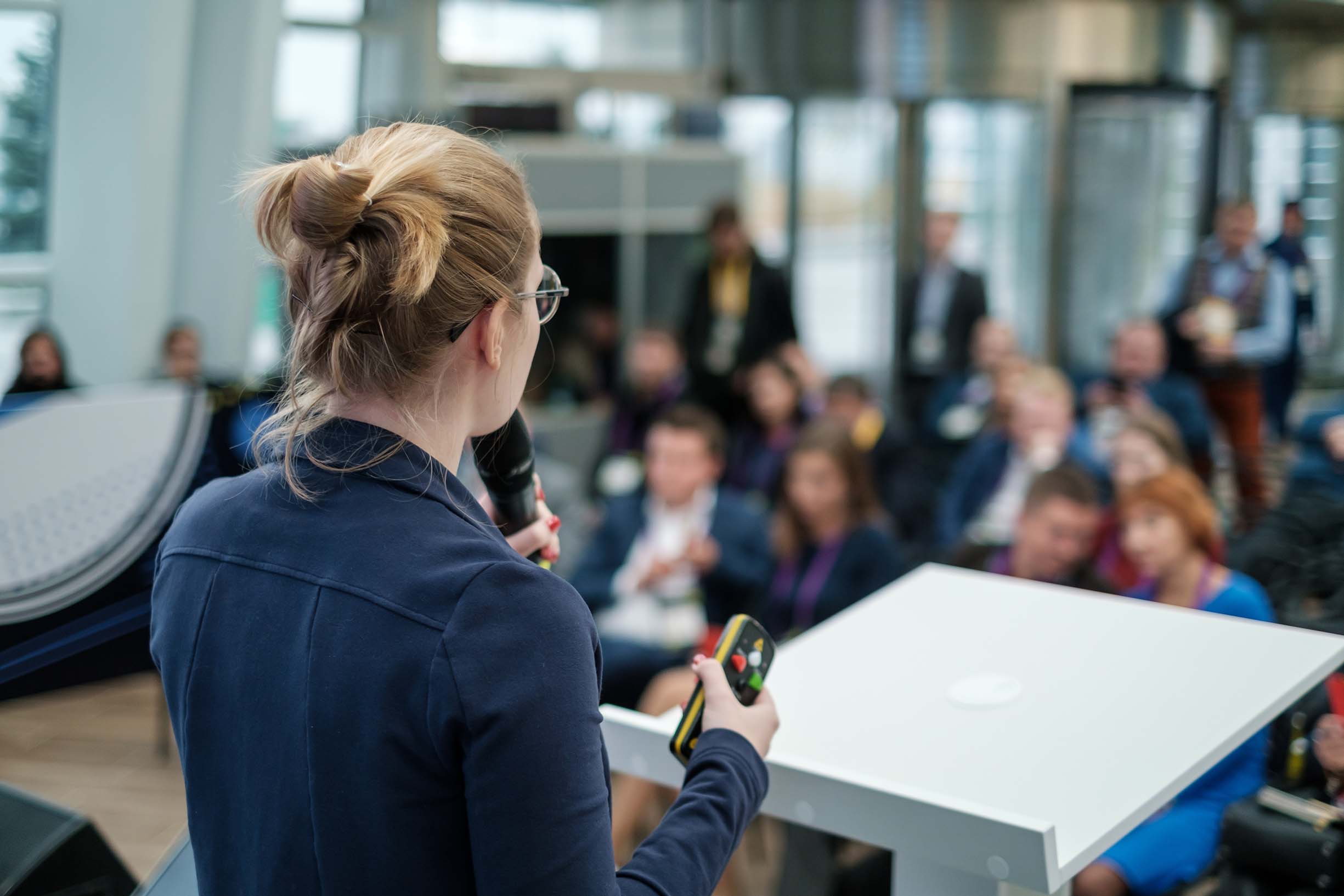 Leader standing at a podium speaks at conference