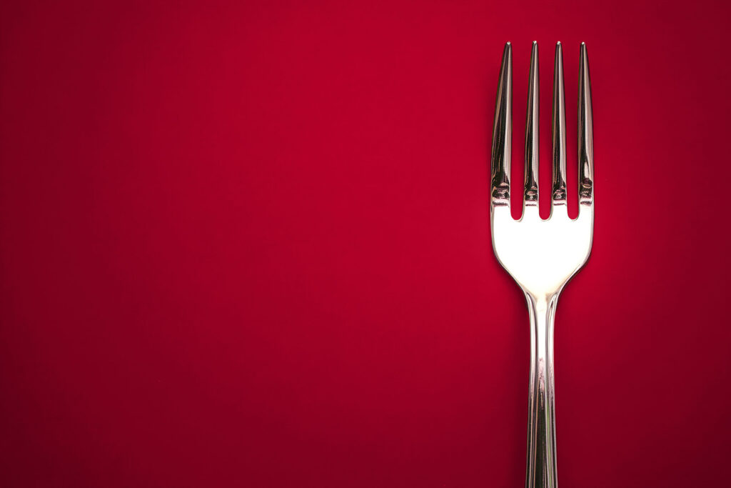 Single fork displayed off center on a red background