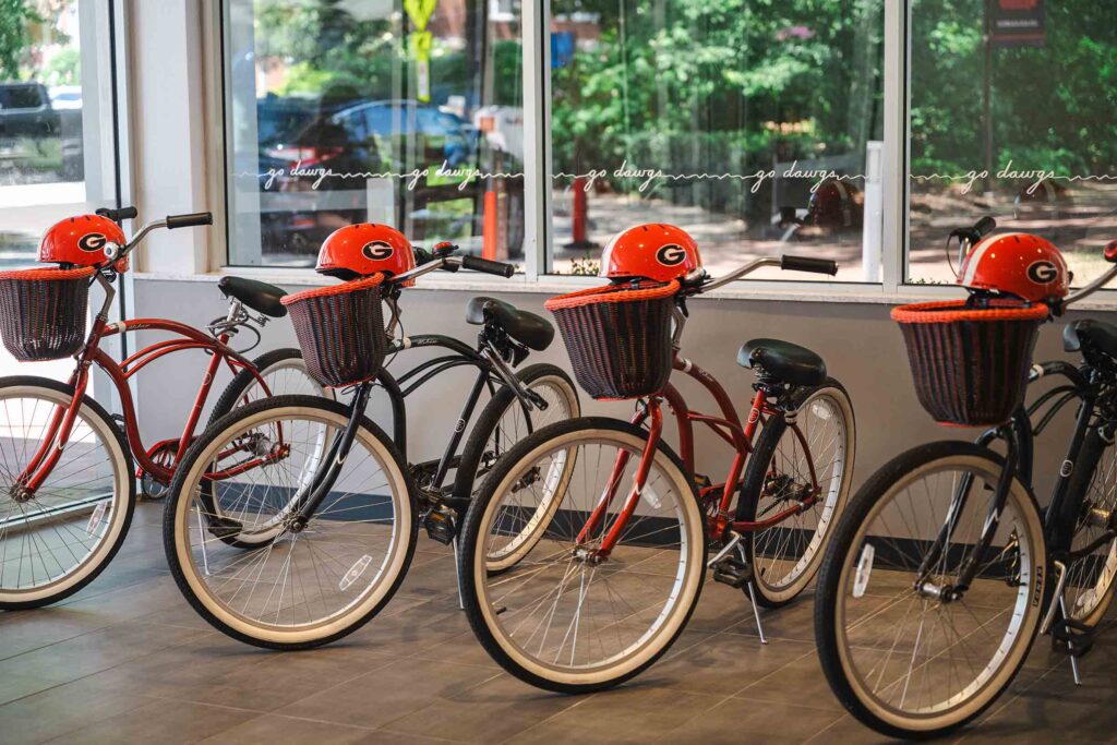 Four bicycles with red helmets inside the hotel concierge area.