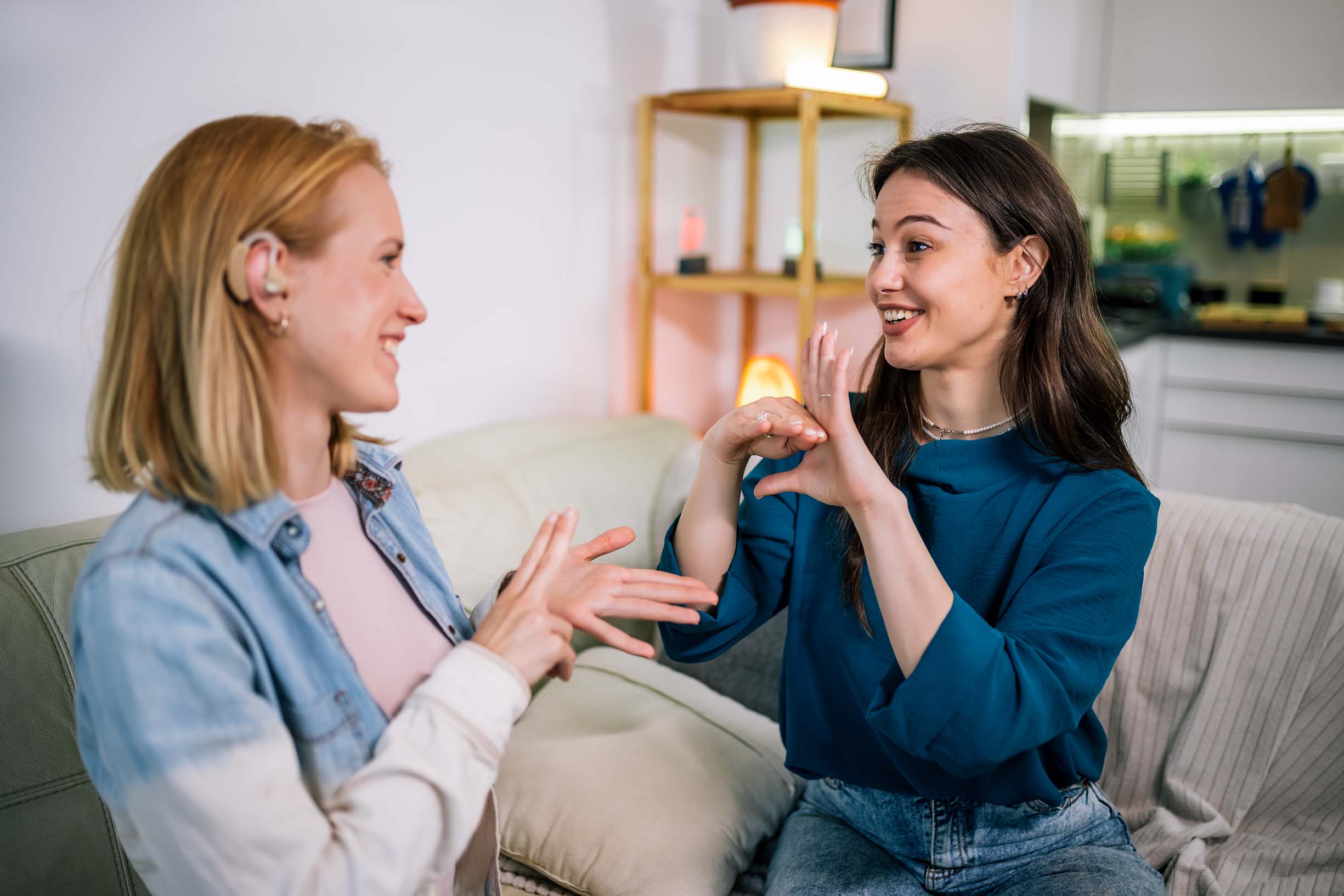 Two women are using sign language to talk to each other.