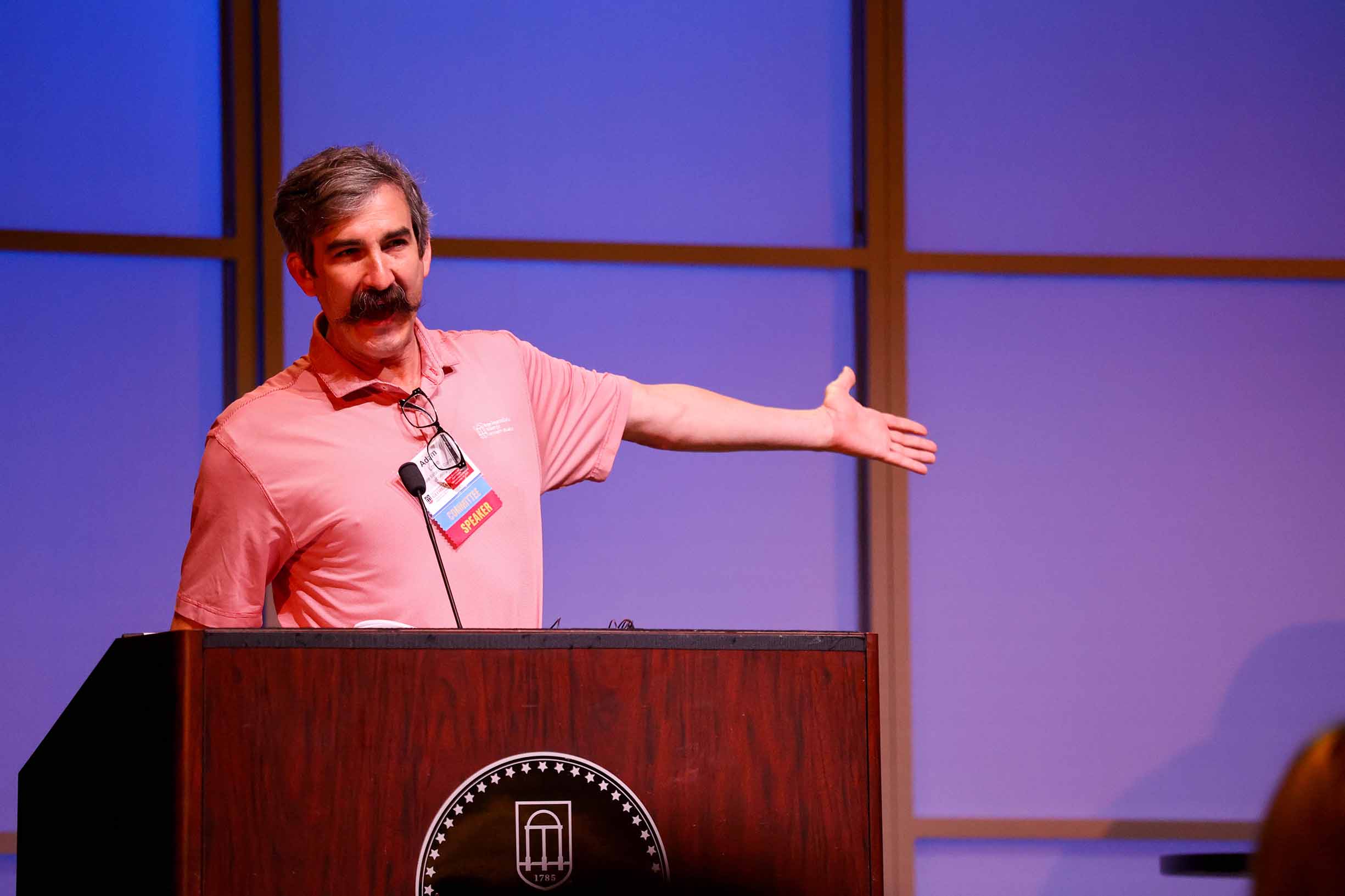 A speaker standing at a podium in Mahler Hall.